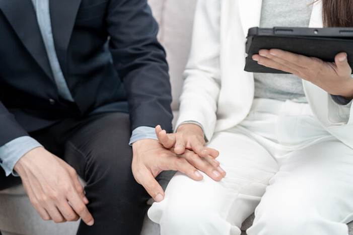 Woman pushing mans hand off her thigh - Sexual harassement